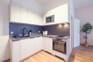 a kitchen with white cabinets and a sink at LeonArt Living 21 in Graz