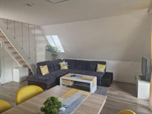 a living room with a blue couch and a table at Ferienwohnung in Schonwald im Schwarzwald