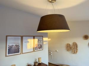 a black light hanging from a ceiling with pictures on the wall at Au soleil couchant in Villeneuve-lès-Béziers