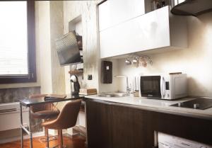 a kitchen with a microwave and a counter with chairs at Urban Loft 56 Moscova- Metro 2 min - TheModelsApartment in Milan