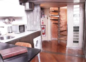 a kitchen with a stove and a microwave and a staircase at Urban Loft 56 Moscova- Metro 2 min - TheModelsApartment in Milan +24 photos
