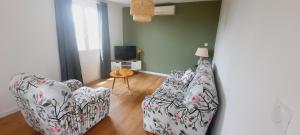a living room with two chairs and a table at Le Balcon de Cournon, piscine, jardin, clim à 15 min de plages in Cournonterral