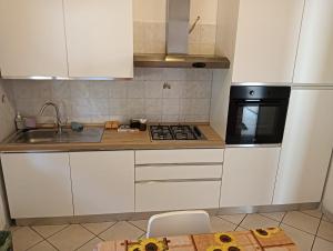 a kitchen with white cabinets and a stove top oven at SunFra Retreat in Belvedere Marittimo