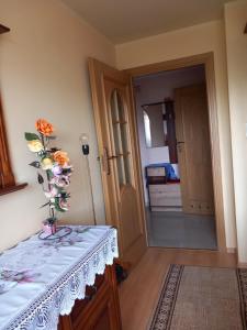a room with a table with a vase of flowers on it at Widoczek in Polańczyk +4 photos