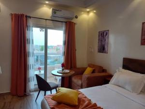 a bedroom with a bed and a couch and a table at Zebra Residence in Rufisque