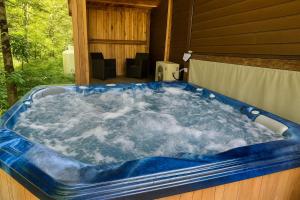 a jacuzzi tub on the side of a house at Chalet Beaulieu - Spa - Piscine - Sauna - Billard in Pont-Rouge