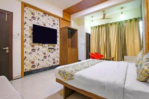 a bedroom with a bed and a tv on a wall at FabExpress Sugar Cube in Somarda Kauasot +18 photos