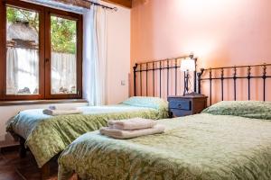una camera da letto con due letti con asciugamani sopra di La Esperilla De Gredos a Navarredonda de Gredos