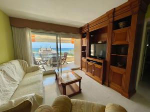 a living room with a couch and a television at Penthouse w/ sea view, pool & beach in Calafell