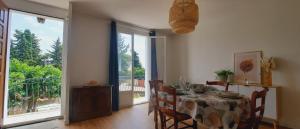 a dining room with a table and a large window at Le Balcon de Cournon, piscine, jardin, clim à 15 min de plages in Cournonterral