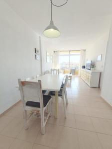una sala da pranzo con tavolo e sedie bianchi di Alquilaencanarias-Medano Lagos de Miramar I a El Médano