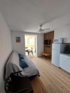 a bedroom with a bed and a kitchen with a table at Appart avec loggia en front de mer et superbe vue in Le Barcarès