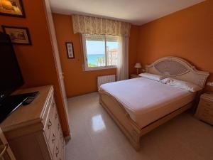 a bedroom with a bed and a window and a television at Penthouse w/ sea view, pool & beach in Calafell +13 photos