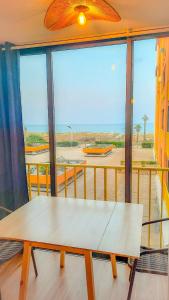 un tavolo in una stanza con una grande finestra di Appart avec loggia en front de mer et superbe vue a Le Barcarès