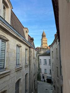 a view of a building with a clock tower in the distance at Grands appartements dans la vieille ville in Périgueux