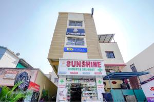 a building with a sun shine sign in front of it at FabHotel Komfort Inn - Nr Twin Tower in Yeraoda