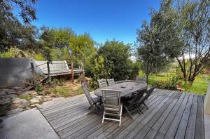 a wooden table and chairs on a wooden deck at The Happy Place, private cottage with rustic pool in Van Wyksdorp +59 photos
