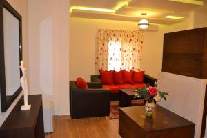 a living room with a black couch and red pillows at Serail Hotel in Ehden