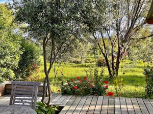 a wooden deck with a chair and some flowers at The Happy Place, private cottage with rustic pool in Van Wyksdorp