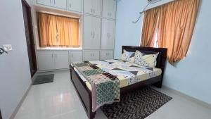 a bedroom with a bed and a window at Yashwithaa Homestay Tirupati - New Hill View Apartments with Balcony, AC, WiFi, TV in Tirupati