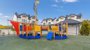 a playground with colorful equipment in front of a house at Bałtycka Oaza, Sun & Snow in Tupadły