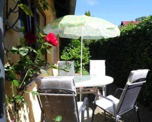 einen Tisch und Stühle mit einem Tisch und einem Sonnenschirm in der Unterkunft Ferienappartements Haus Fischersruh in Lauterbach
