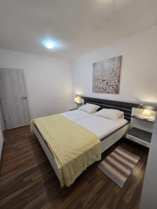 a bedroom with a bed and a painting on the wall at Apartman Anita in Jesenice
