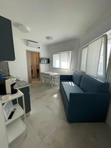 ガビッチェ・マーレにあるResidenze Porto Canaleの青いソファとテーブルのあるリビングルーム