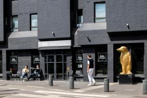 a statue of a dog on a sidewalk in front of a building at ibis Styles Hasselt City Centre in Hasselt