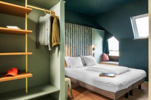 a bedroom with a bed in a blue room at ibis Styles Hasselt City Centre in Hasselt +137 photos