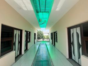 Chandigarh AirportMahadev Hotel !! Near Chandigarh Int'l Airport !的一栋建筑的空走廊，地板上有一个游泳池
