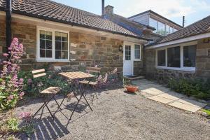 a house with a table and chairs in front of it at Host & Stay - Lane Farm Cottage in Easington