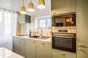 Maison Spa et Sauna, Cœur de la Normandie في Ranville: مطبخ مع حوض وموقد الفرن العلوي +17 صورة