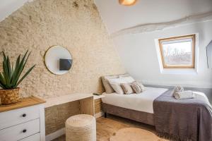 Maison Spa et Sauna, Cœur de la Normandie في Ranville: غرفة نوم بها سرير ومرآة