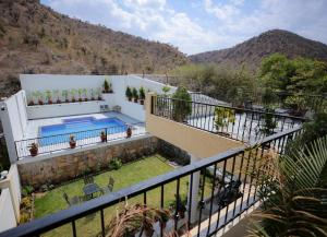 a villa with a swimming pool and mountains in the background at Chandravillakotharia in Nāthdwāra