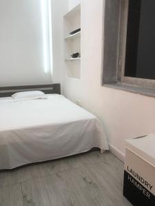 a white bedroom with a bed and a box at Mutamba Prime Stay in Luanda +24 photos