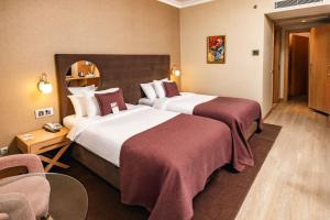 a hotel room with two beds and a chair at WOW Airport Hotel in Istanbul +47 photos