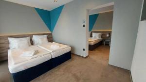 a bedroom with a large bed and a room with a bedroomswersswersswersswers at Hotel Szieszta in Sopron