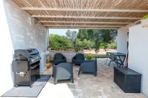 a patio with a grill and chairs and a table at Villa Serenità in San Vito dei Normanni