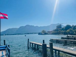 a view of a lake with a dock and a flag at Apartment Bergliebe Bad Goisern in Bad Goisern