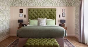 a bedroom with a large bed with a green headboard at The Ashe Hotel in Tralee