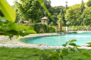 duży basen w ogrodzie z drzewami w obiekcie Appartements Liebe Heimat w Saalbach Hinterglemm