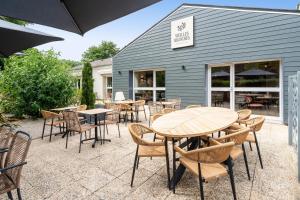 a patio with tables and chairs in front of a building at Sure Hotel by Best Western Tours Sud in Chambray-lès-Tours