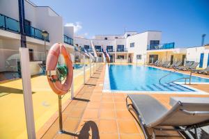 a swimming pool with chairs and a life preserver at TAO El Cotillo - VV in El Cotillo