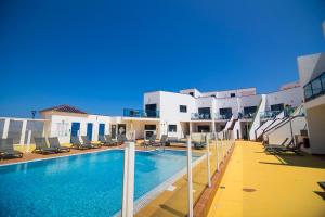 a swimming pool in front of a building at TAO El Cotillo in El Cotillo