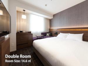 Postel nebo postele na pokoji v ubytování Nishitetsu Hotel Croom Hakata