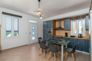 a kitchen and dining room with a table and chairs at Villa Azzure Horizon Pollonia in Pollonia