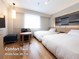 Postel nebo postele na pokoji v ubytování Nishitetsu Hotel Croom Hakata