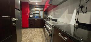 a kitchen with red walls and a counter top at Nasma Homes in Abu Dhabi +10 photos