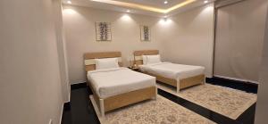 a small room with two beds and a window at Nasma Homes in Abu Dhabi